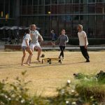 Four students play a game on Stafford Commons.