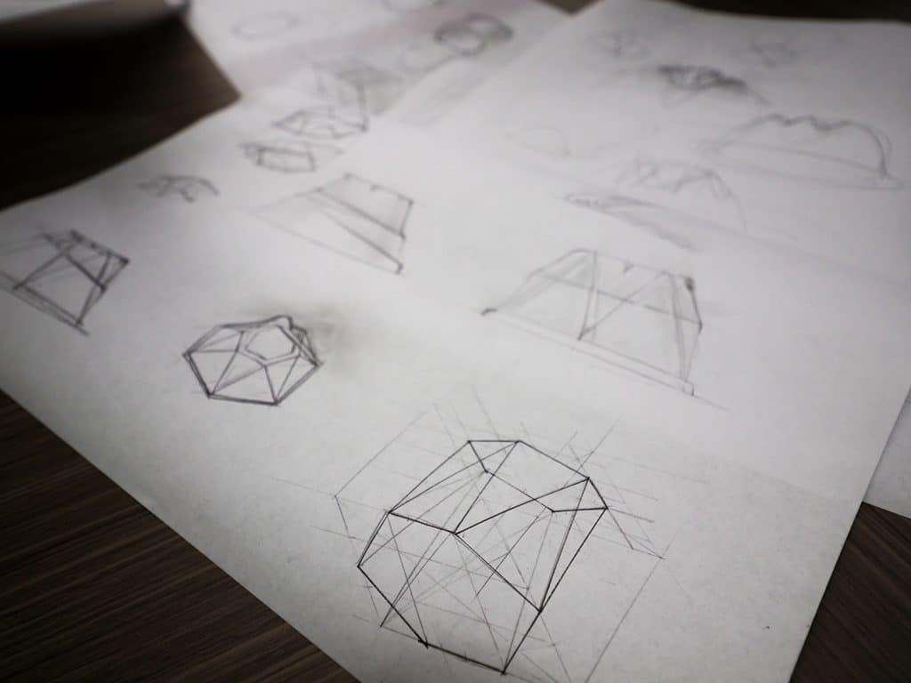 用铅笔在白纸上画出的几何图形显示了外卖容器的草图。