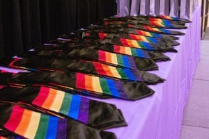 Rainbow graduation stoles are lined up on a display table at the Lav Grad.