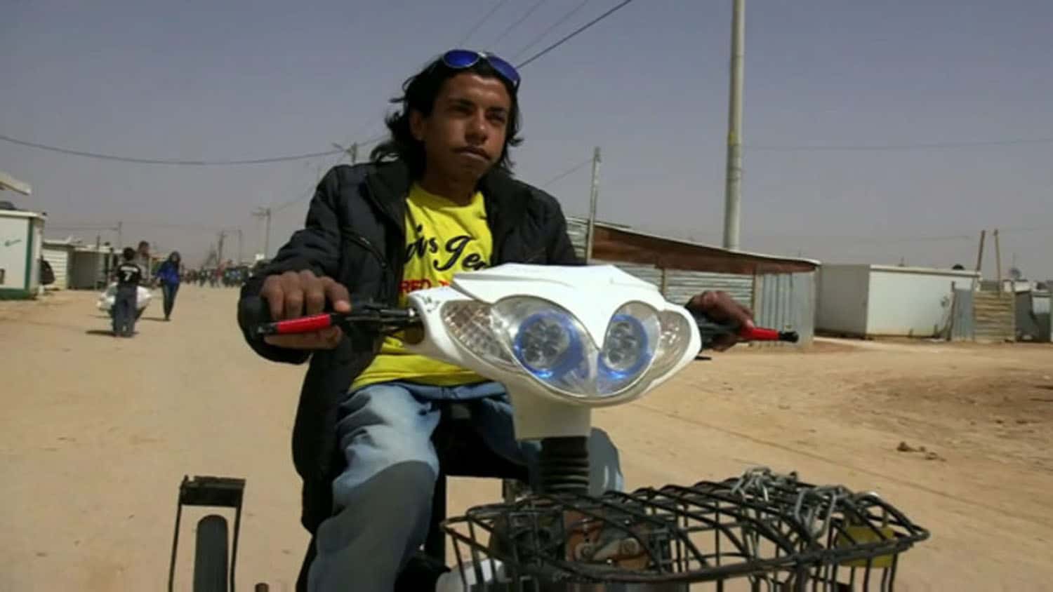 南亚的年轻人在一条小街上骑着机动的自行车