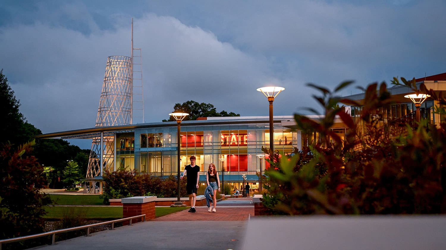 两个学生走在斯塔福德广场，塔利学生会在近处的背景中。