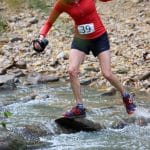 跑步者用系着的绳子在岩石上保持平衡