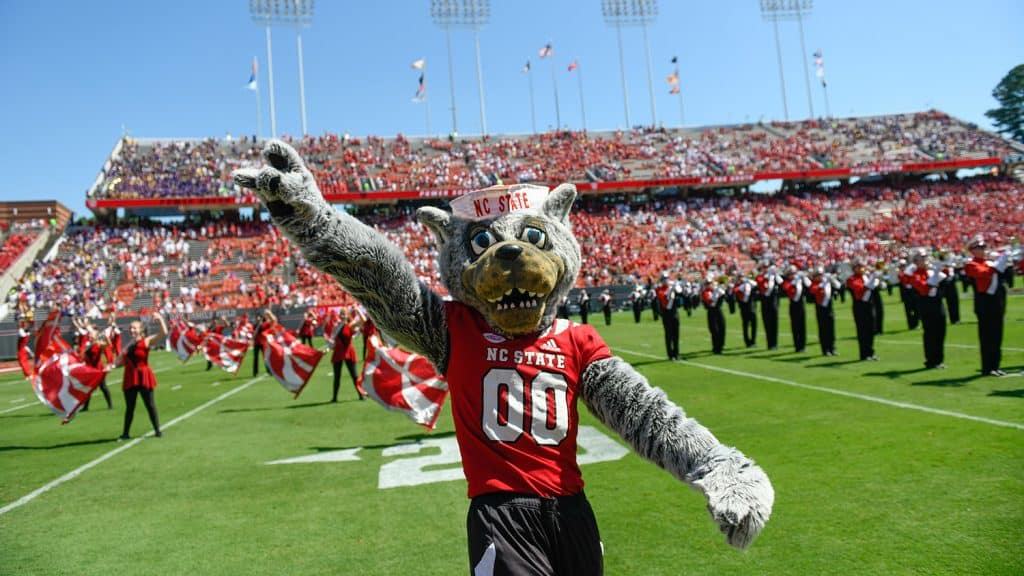 伍夫在足球场上做了一个狼式的手势，背景是军乐队和仪仗队。