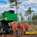 学生们在2022年Schecnk森林采伐活动期间拿着采伐工具摆姿势