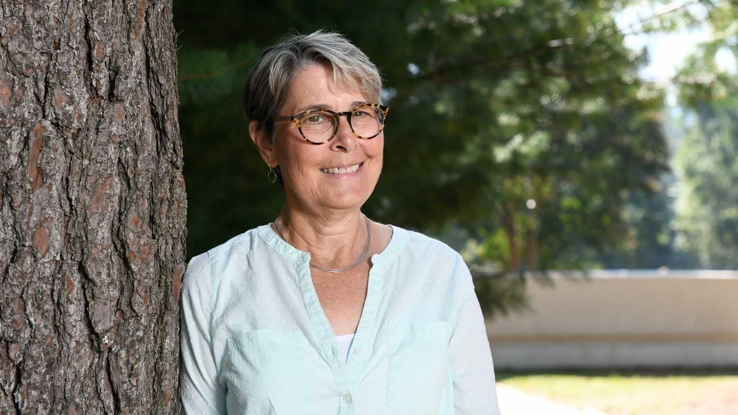 莎拉·艾什倚着树