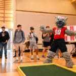 伍夫先生在2022年捐赠日学生活动上玩迷你高尔夫球时庆祝成功推杆