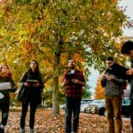 Dr. Steph Jeffries (left) teaches tree identification during a dendrology class outside Jordan Hall on a fall day, with leaves littering the ground nearby.