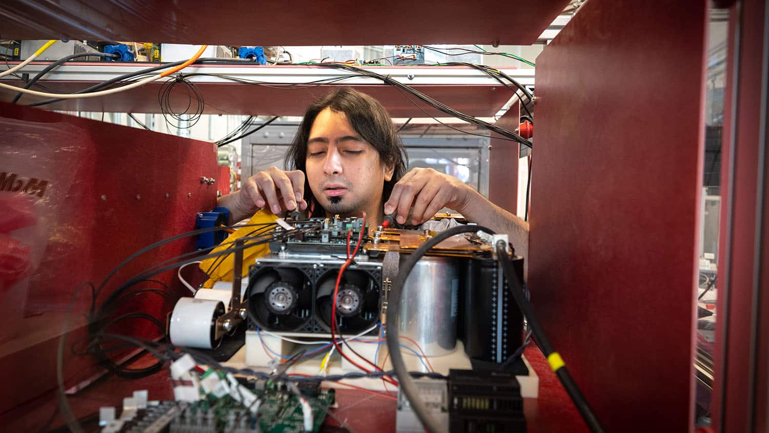 一位研究生在百年纪念校园的FREEDM中心工作。2008年，美国国家科学基金会(National Science Foundation)选择北卡州立大学领导一项建设现代电网的工作。在未来可再生电力输送和管理(FREEDM)系统工程研究中心，来自美国的大学与行业合作伙伴联手开发更安全、可持续和环保的电网。