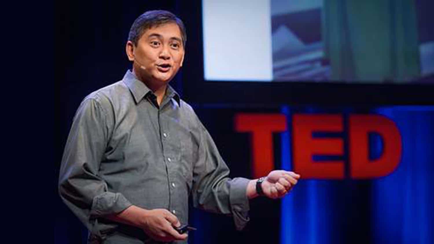 Dr. Francis de los Reyes stands on a stage addressing listeners for a TED Talk on 