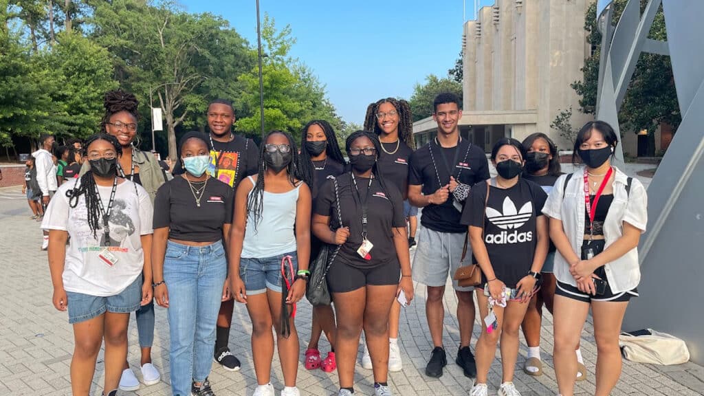 Incoming first-year students pose in front of Reynolds Coliseum on the first day of the Symposium for Multicultural Scholars.