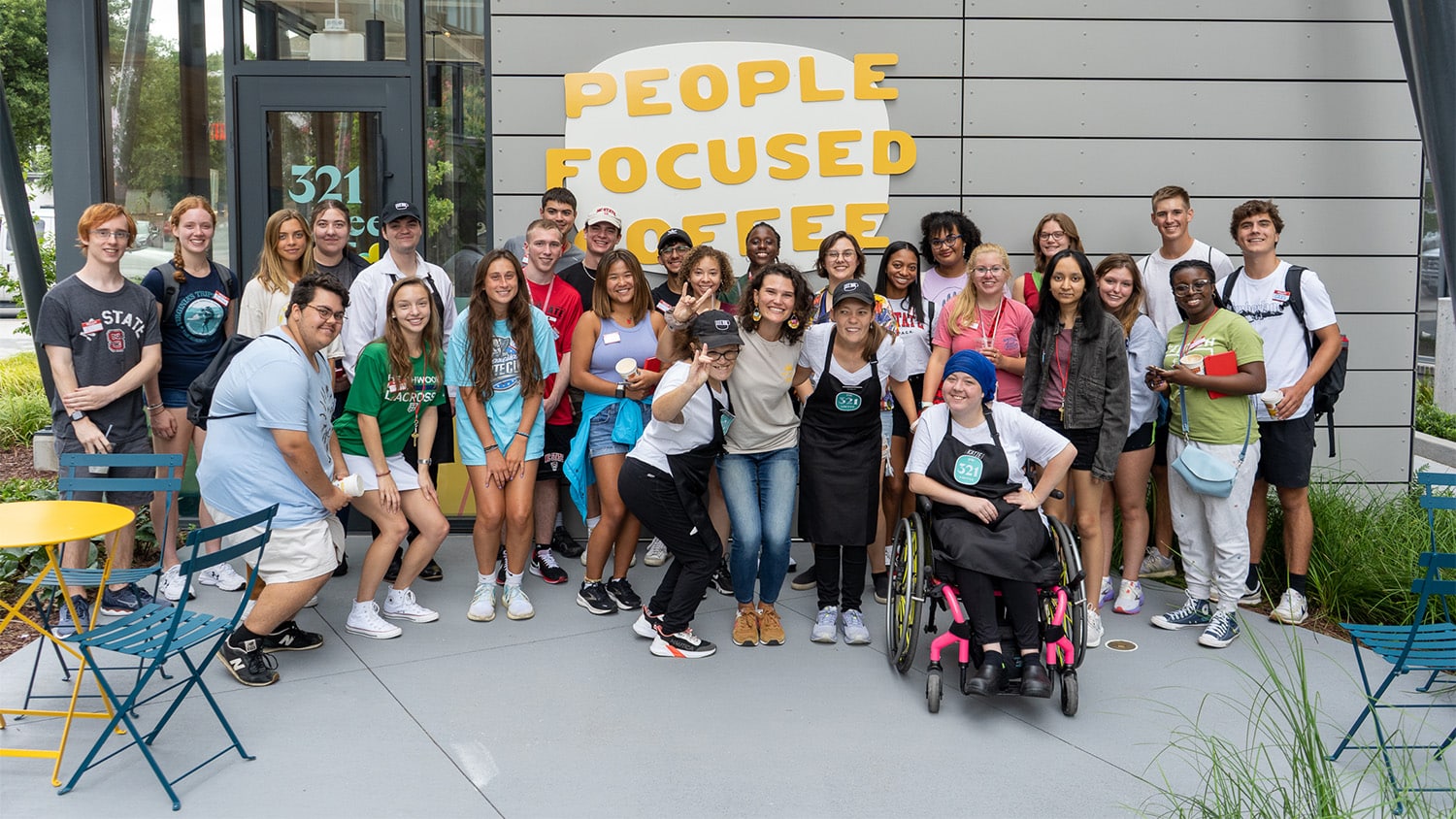 A large group of students and 321 Coffee staff in front of the business