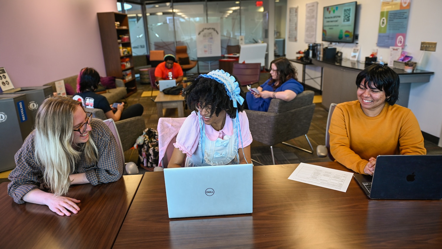 Three students work at a table in the LGBTQ Pride Center.