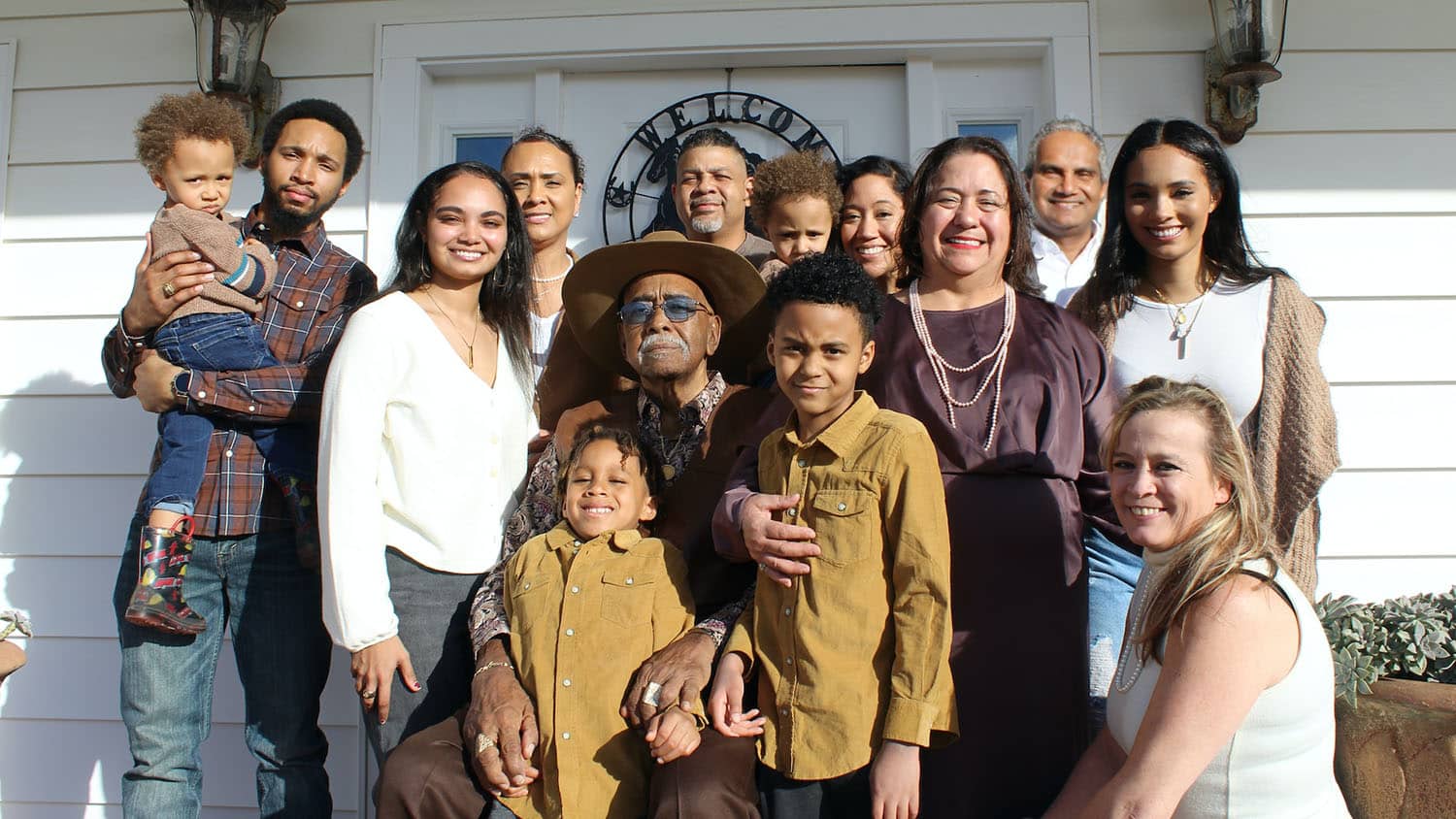 photo shows three generations of a family standing on the front steps of a house