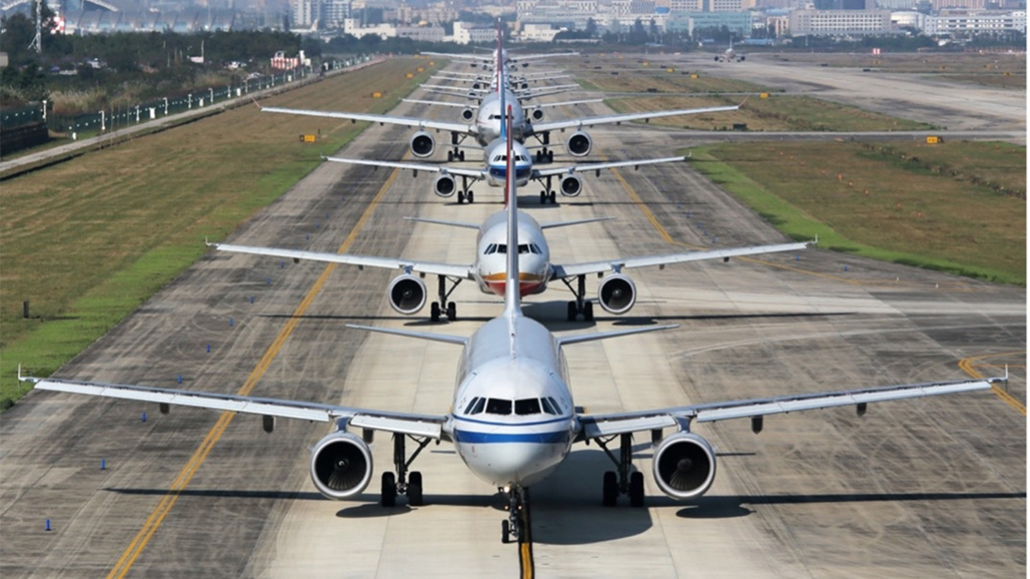 Airplanes lined up on an airport runway