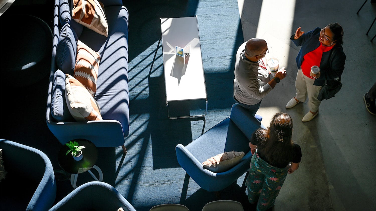 向下看一组教职员工在咖啡桌和家具旁聊天