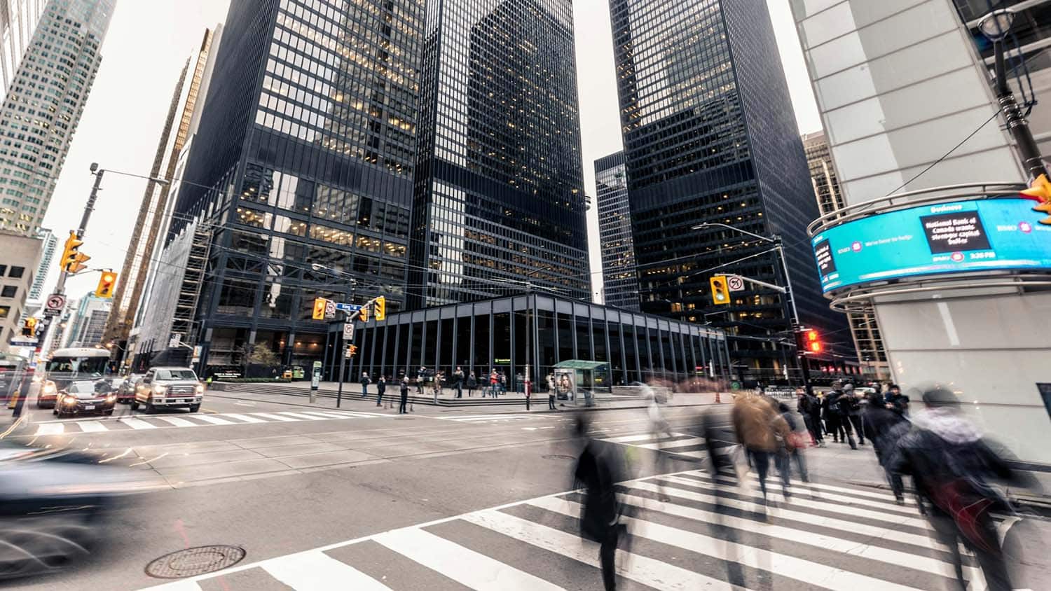 照片显示行人和汽车穿过城市繁忙交叉路口