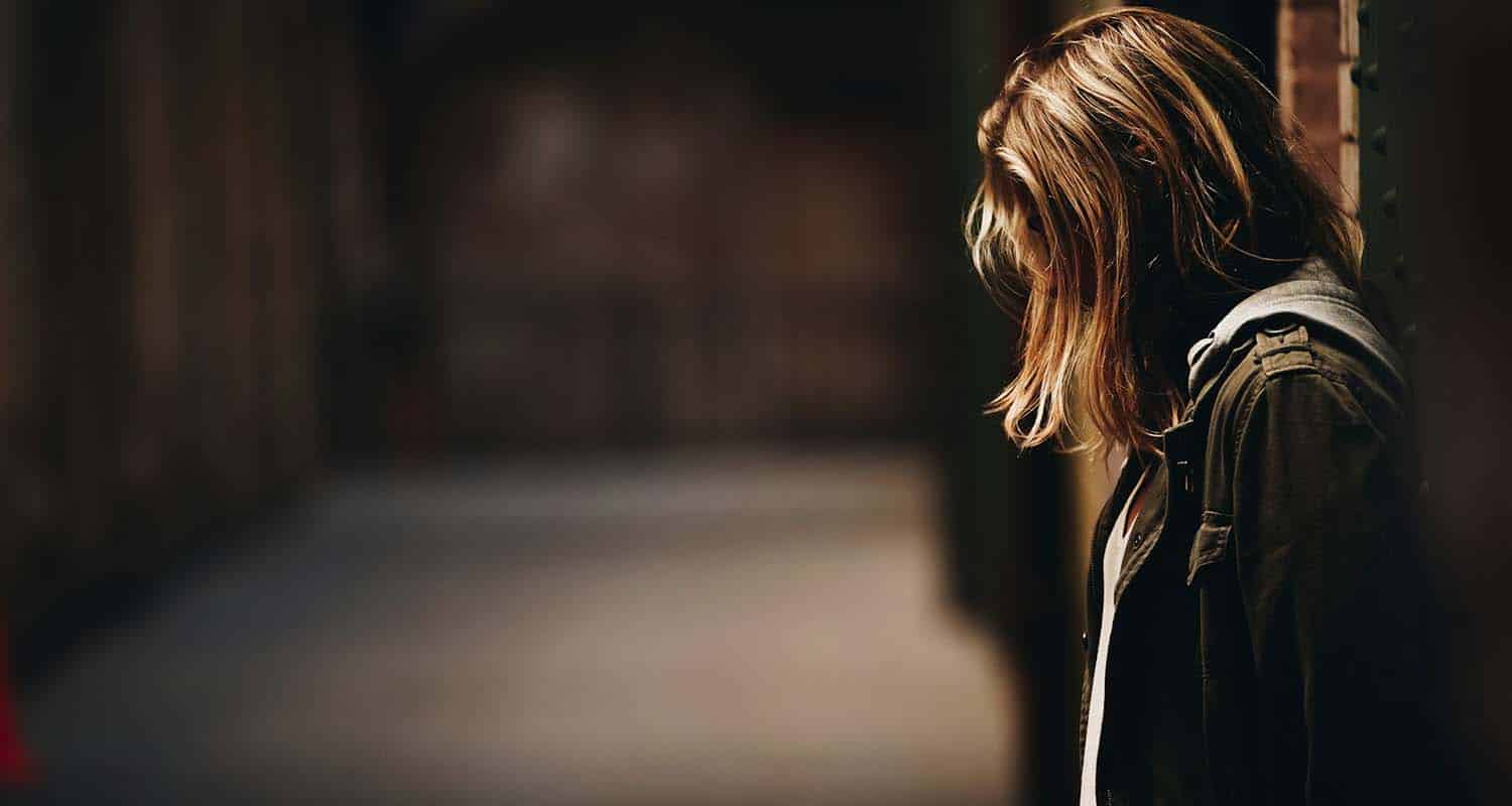 年轻女人靠墙 头发挂在脸上