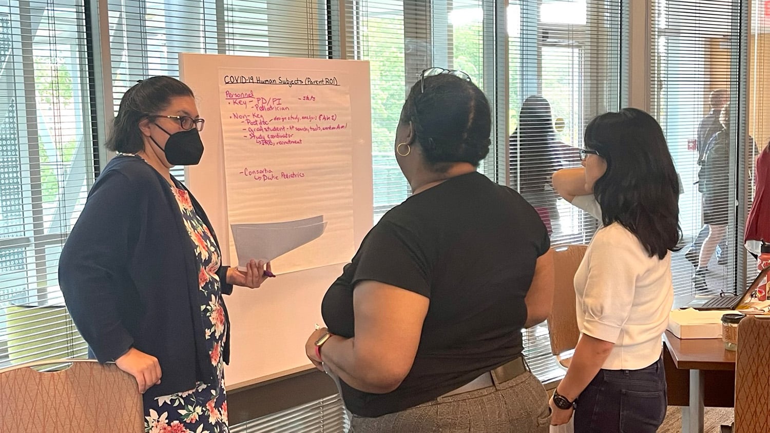 Molly Puente和两位同事谈海报